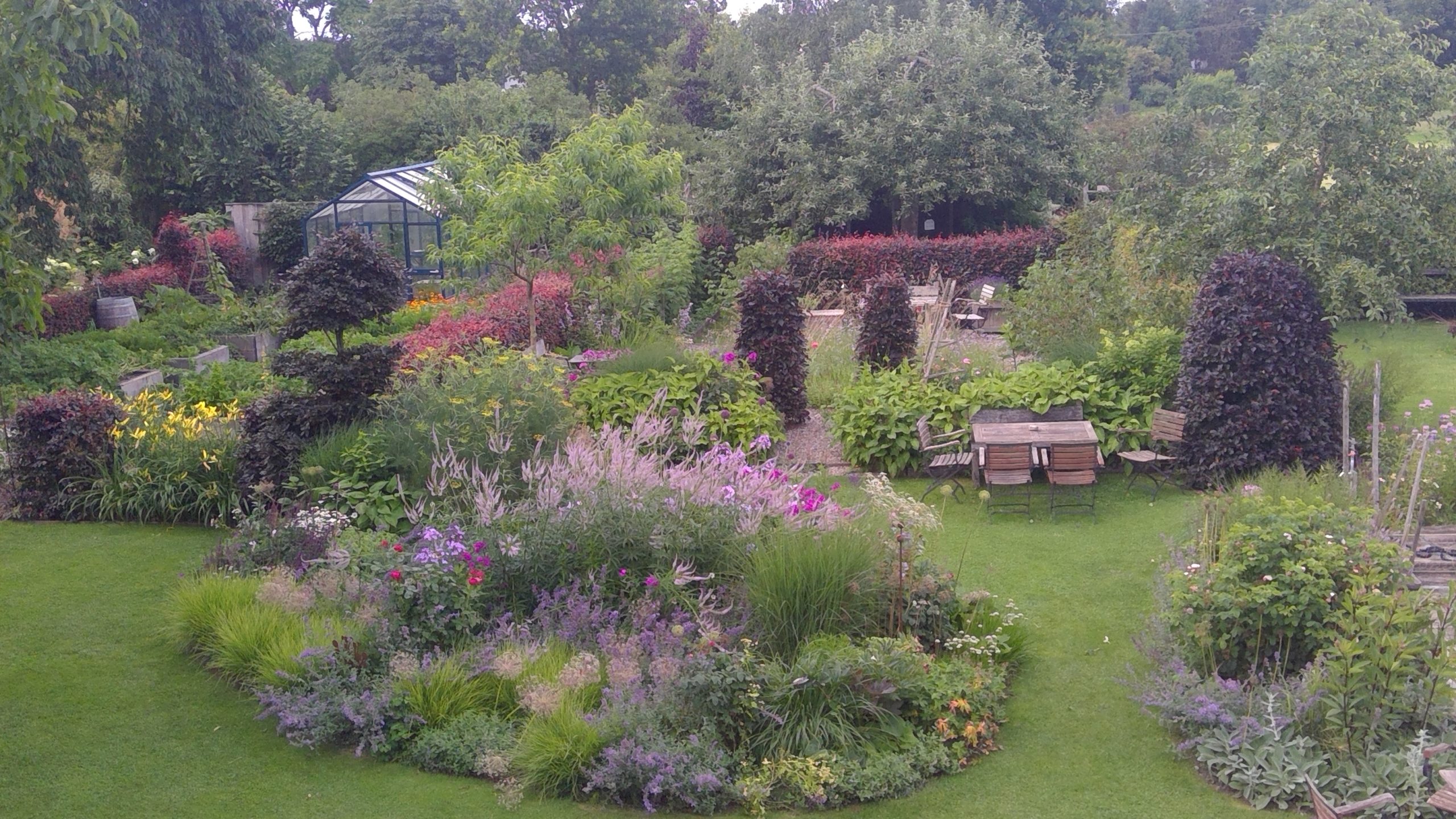 Blumenbeet und Küchengarten im Sommer